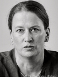 Das schwarz-weiß-Foto zeigt eine Frau in Frontalansicht. Es ist eine Abbildung von Moderatorin Alexandra Kemmerer.