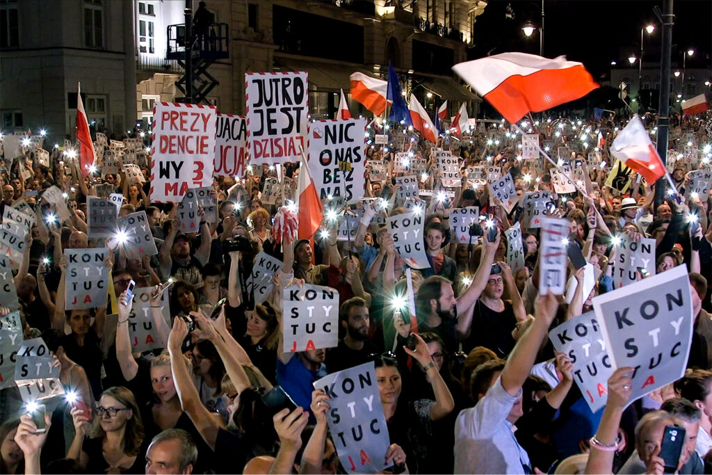 Eine demonstrierende Masse, die sich gegen den Abbau des polnischen Rechtsstaats einsetzt und viele bunte Schilder hochhält.
