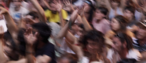 Foto: Unscharf eine tanzende Menschenmenge mit erhobenen Händen