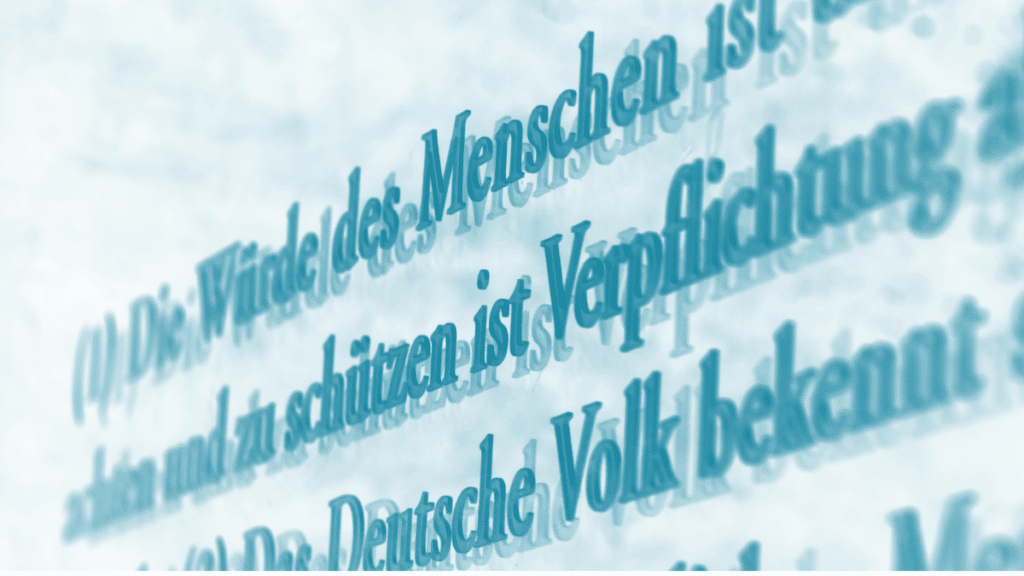 Foto eines Grundgesetztextes auf einer Glasstehle. Der Ausschnitt zeigt Teile von Artikel 1 "Die Würde des Menschen ist unantastbar..."