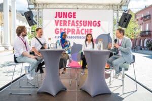 Blick auf die Bühne bei den Jungen Verfassugsgesprächen. Junge Menschen diskutieren hier über Aspekte des Grundgesetzes.