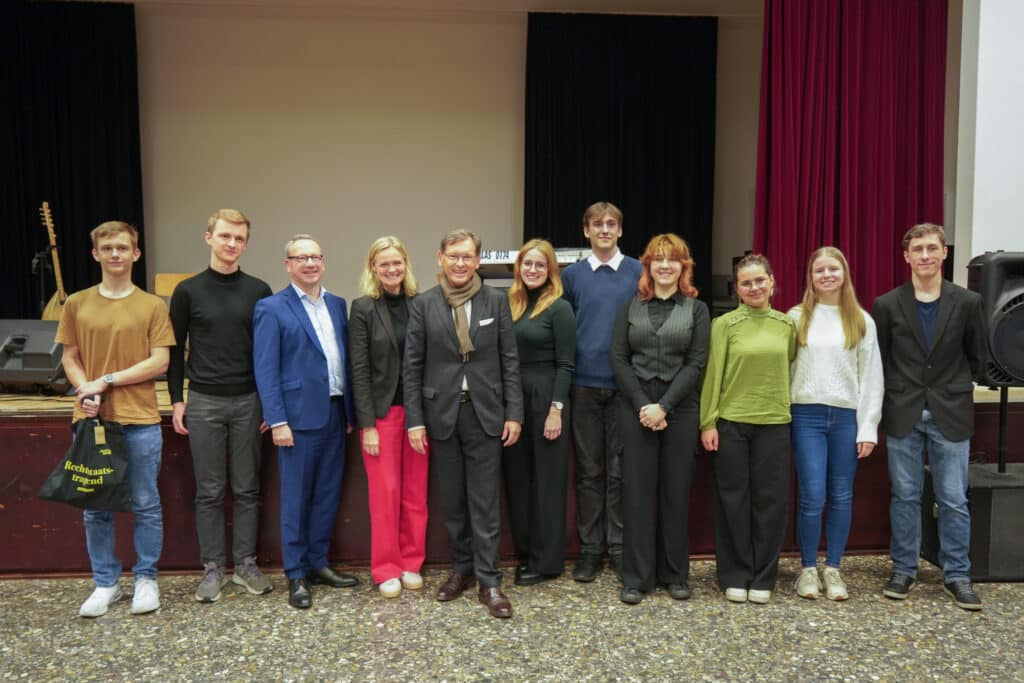 Gruppenbild mit Schüler:innen und Teilnehmer:innen der Fishbowldiskussion.