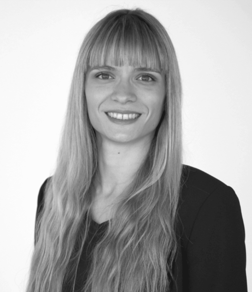 Portrait: A young woman with very long blonde hair and bangs smiles at the camera.