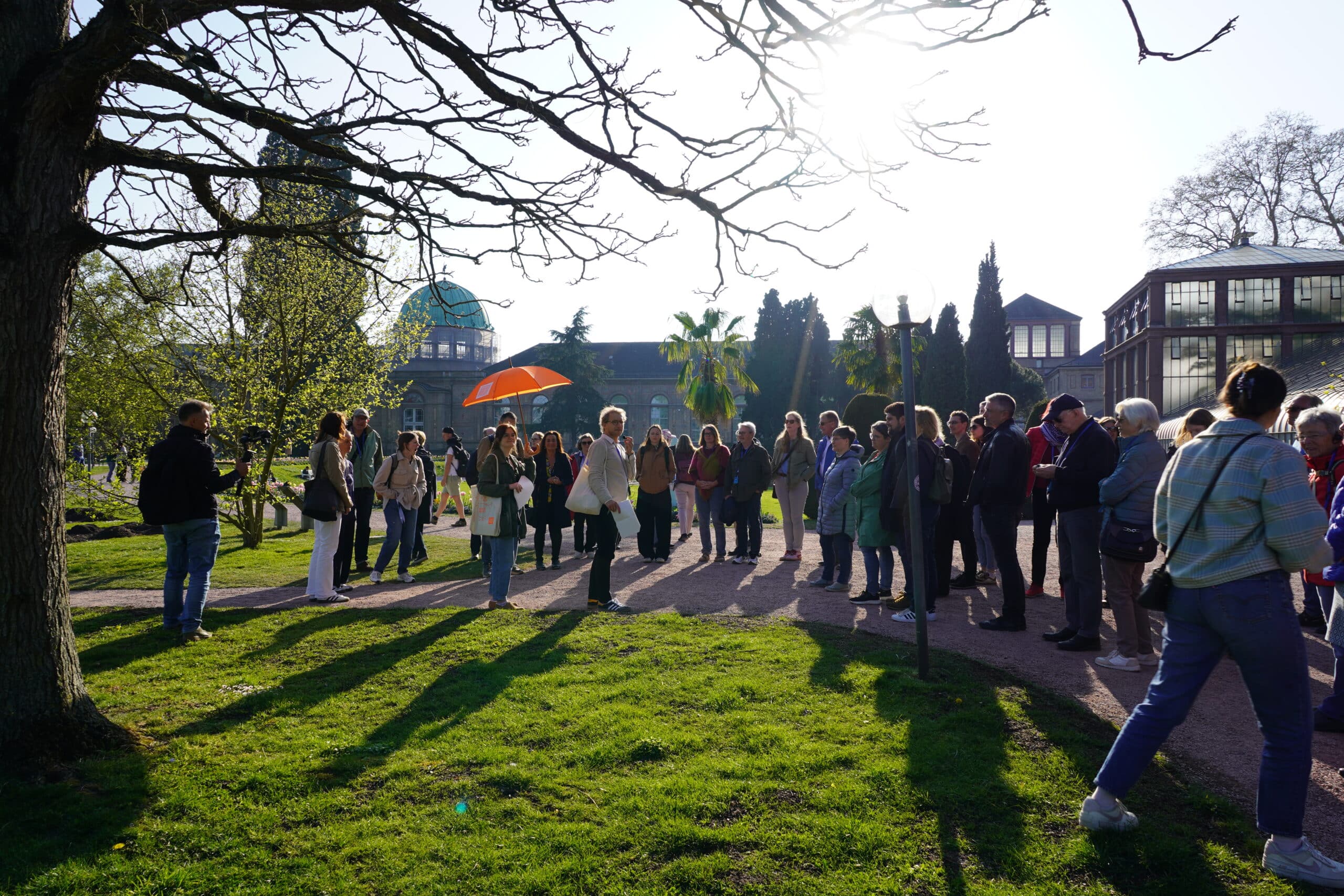 Eine Gruppe beim Stadtrundgang durch Karlsruhe im Park.
