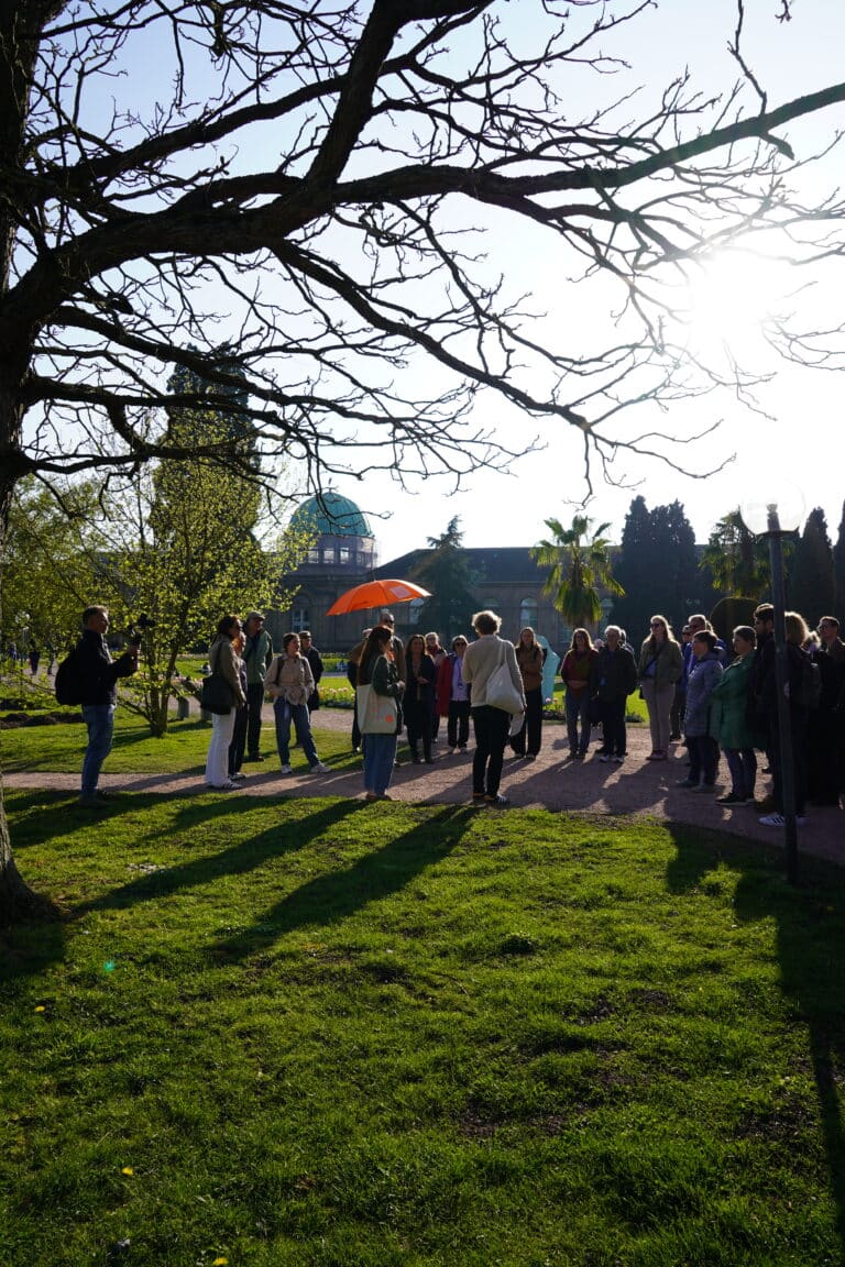 Eine Gruppe beim Stadtrundgang durch Karlsruhe im Park.
