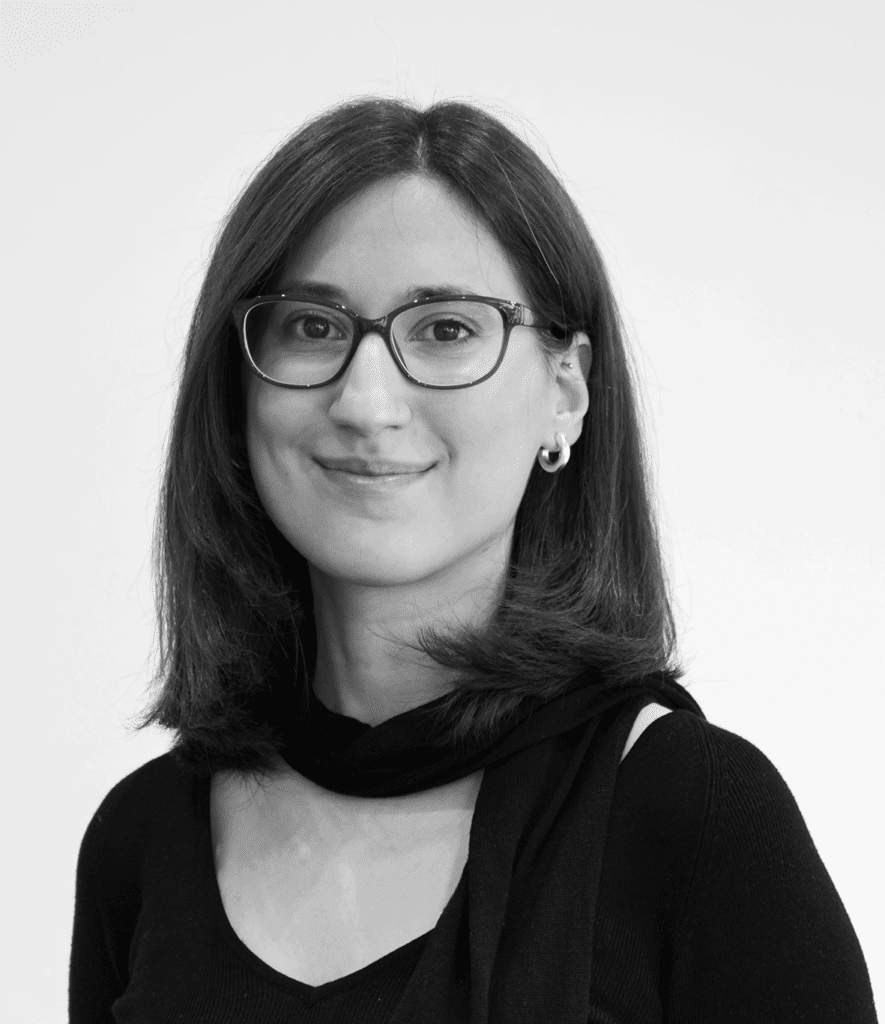 Eine junge Frau mit Brille und schulterlangen Haaren blickt freundlich in die Kamera.