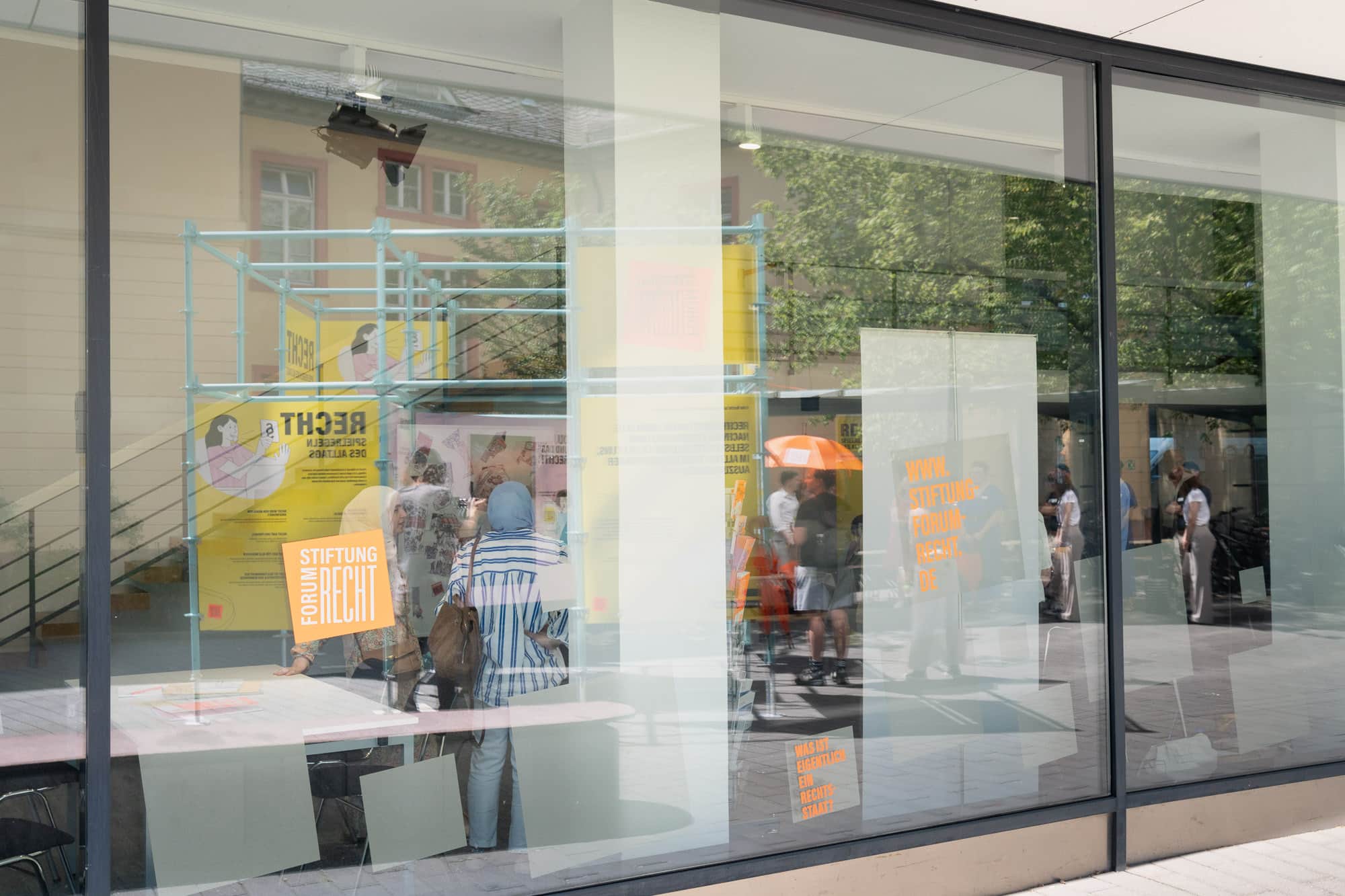 Glasfront der Stiftung von außen fotografiert mit Logoaufklebern in knalligem Orange, Karlsruhe.