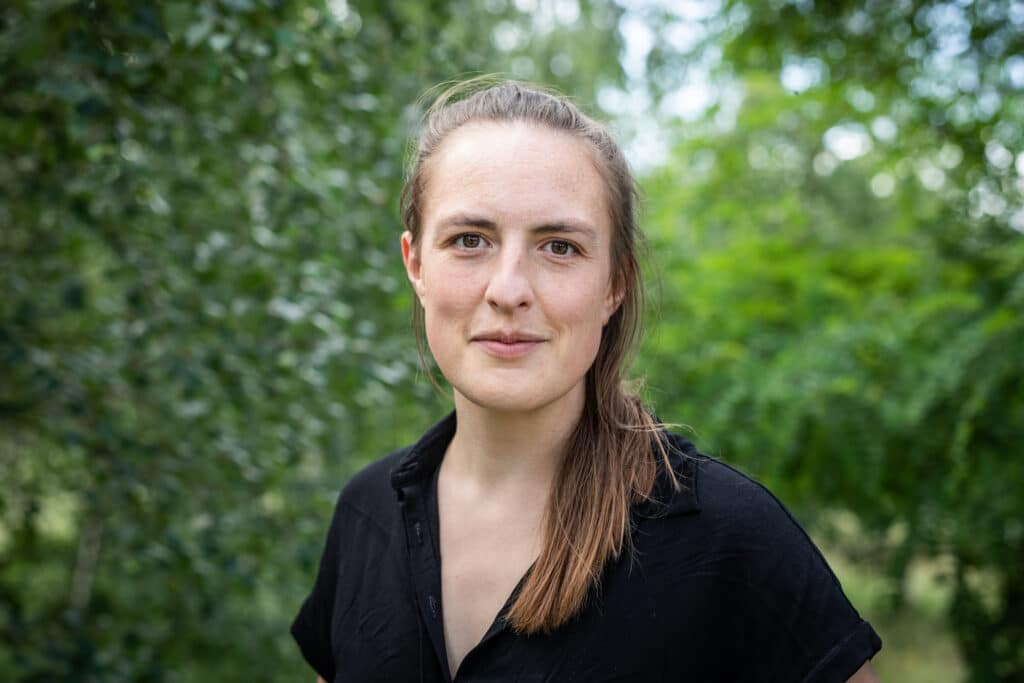 Ein Porträtbild einer jungen Frau mit langen Haaren.