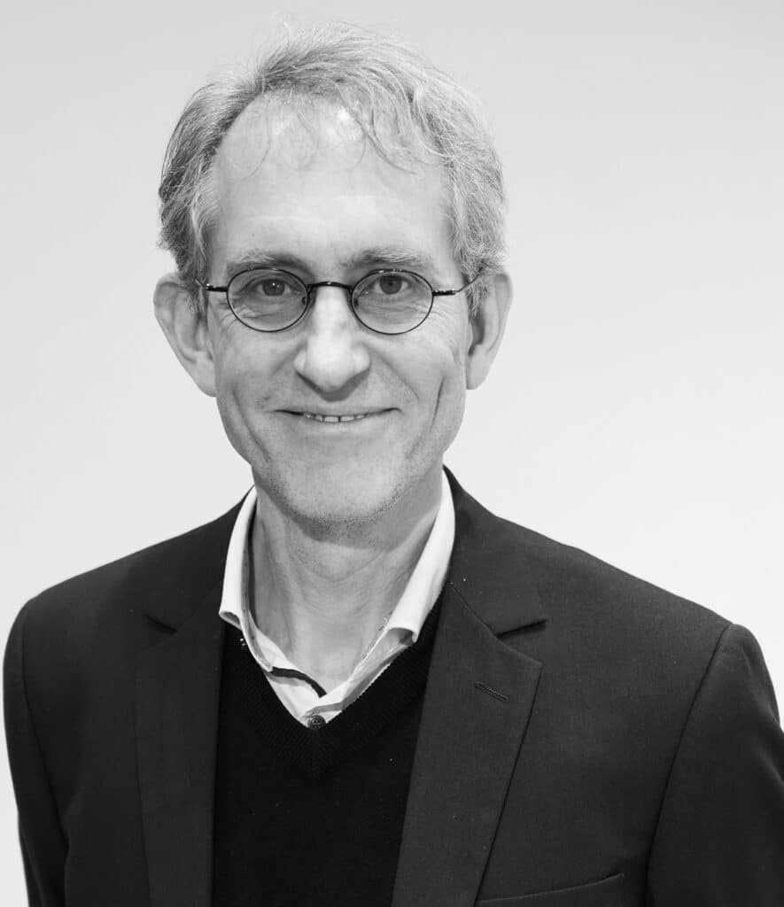 Portrait eines lächelnden älteren Herren mit Brille.