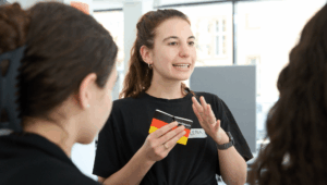 Junge Frau mit Grundgesetz in der Hand argumentier gestenreich.