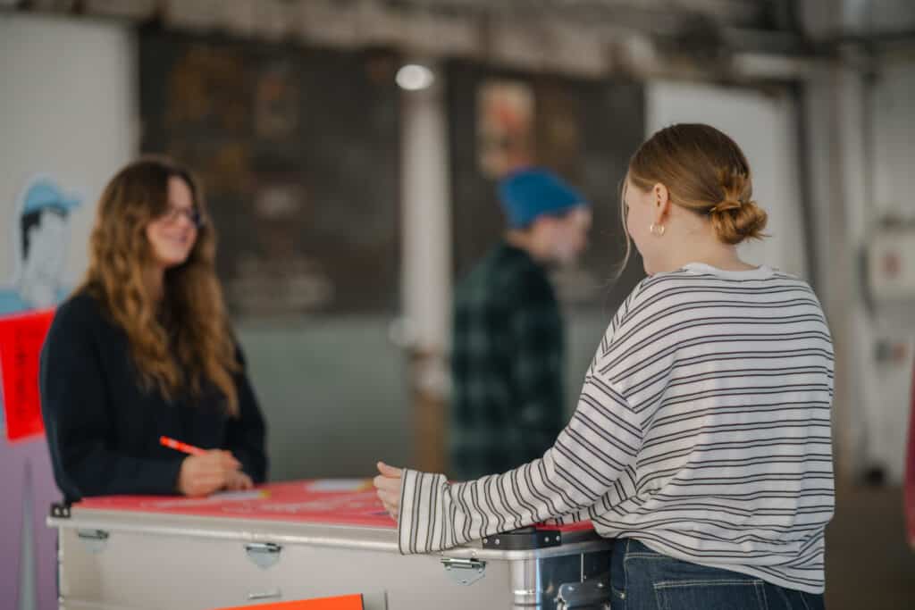 Bildschirmelement der Indoor-Ausstellung "Recht - Spielregeln des Alltags" und Postkartenbox.