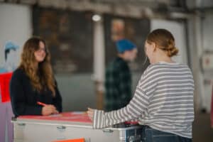 Bildschirmelement der Indoor-Ausstellung "Recht - Spielregeln des Alltags" und Postkartenbox.