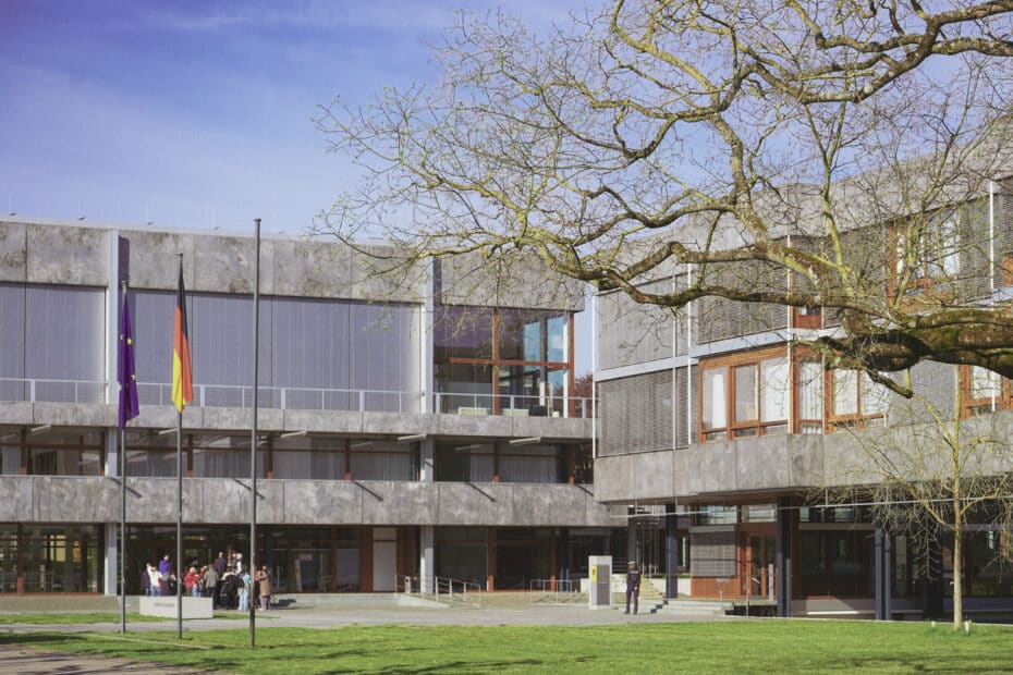 Außenansicht des Bundesverfassungsgerichts in Karlsruhe mit einer Gruppe Besuchender vor dem Eingang.