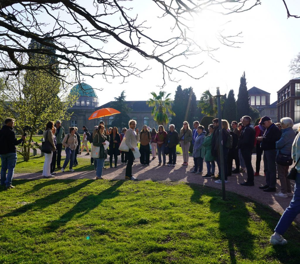 Eine Gruppe beim Stadtrundgang durch Karlsruhe im Park.